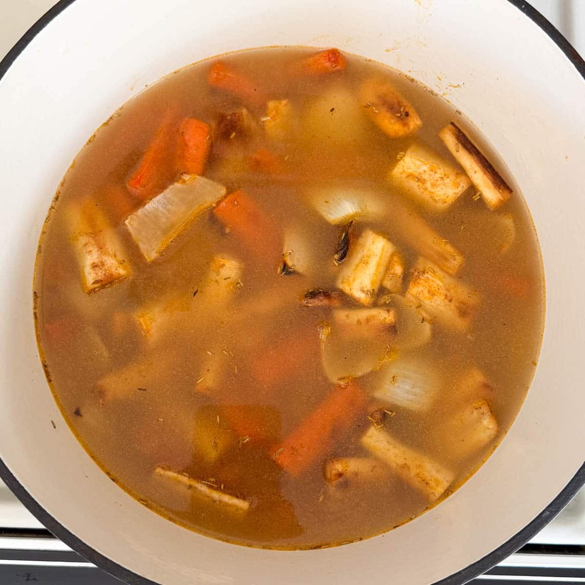 roasted onions, garlic, parsnips and carrots added to soup pot with broth.
