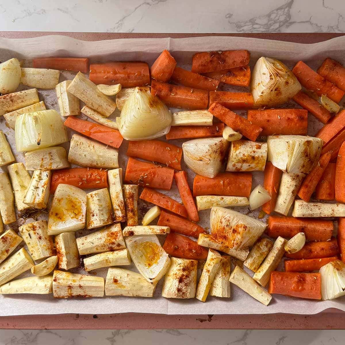 Veggies on baking sheet after roasting halfway through.