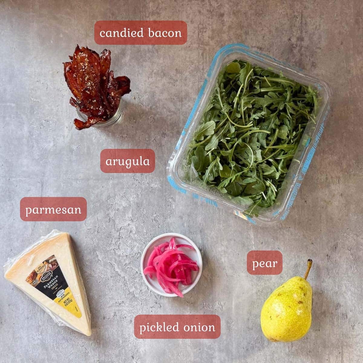 rocket salad ingredients (pear, arugula, parmesan, pickled onion, candied bacon.)