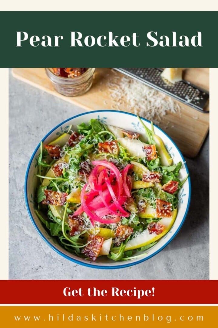 pear rocket salad topped with red onion surrounded by candied bacon and parmesan.