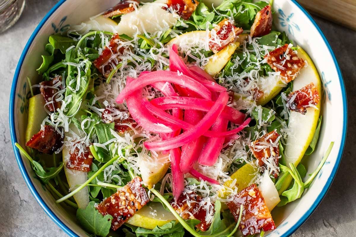 pear rocket salad topped with candied bacon and pickled onion.