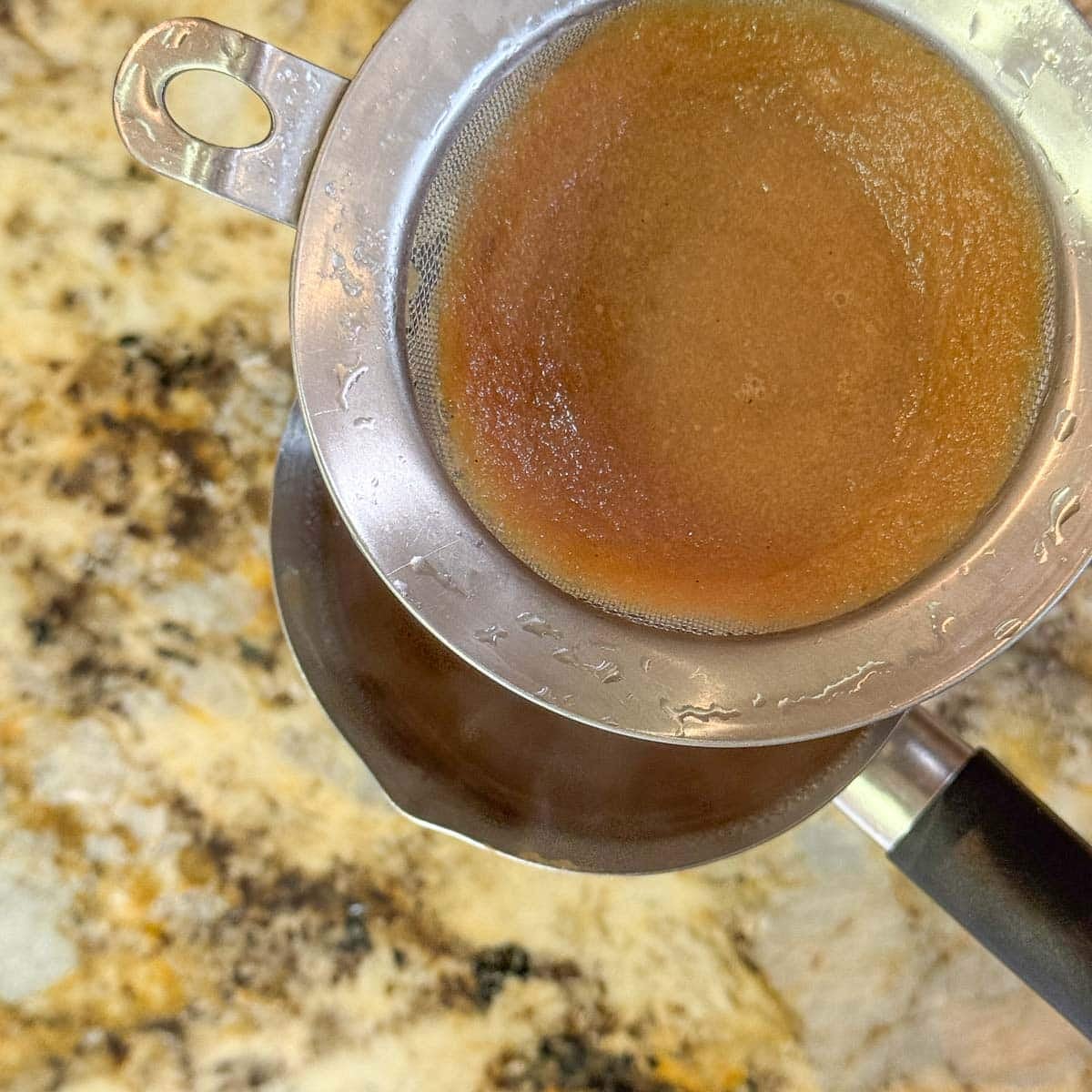 spiced apple cider strained through a fine mesh sieve